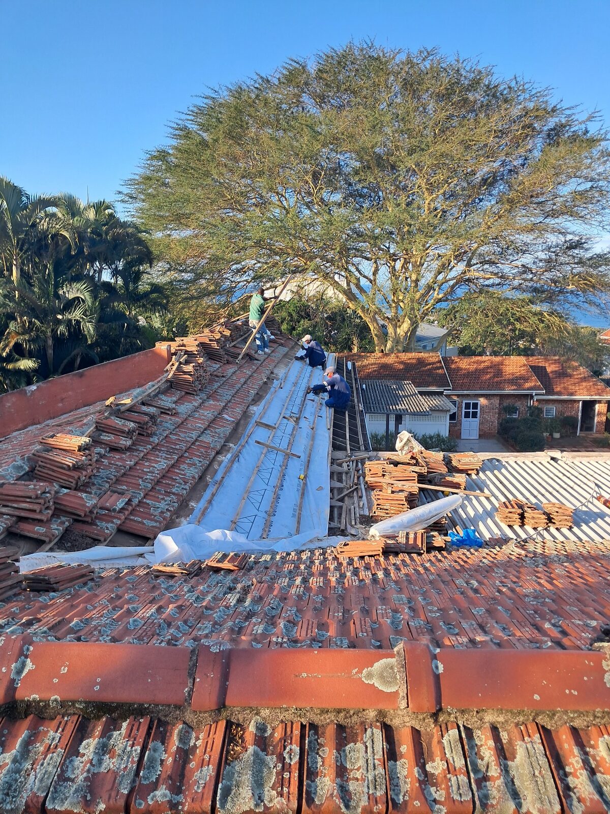 Worker repairing tile roof